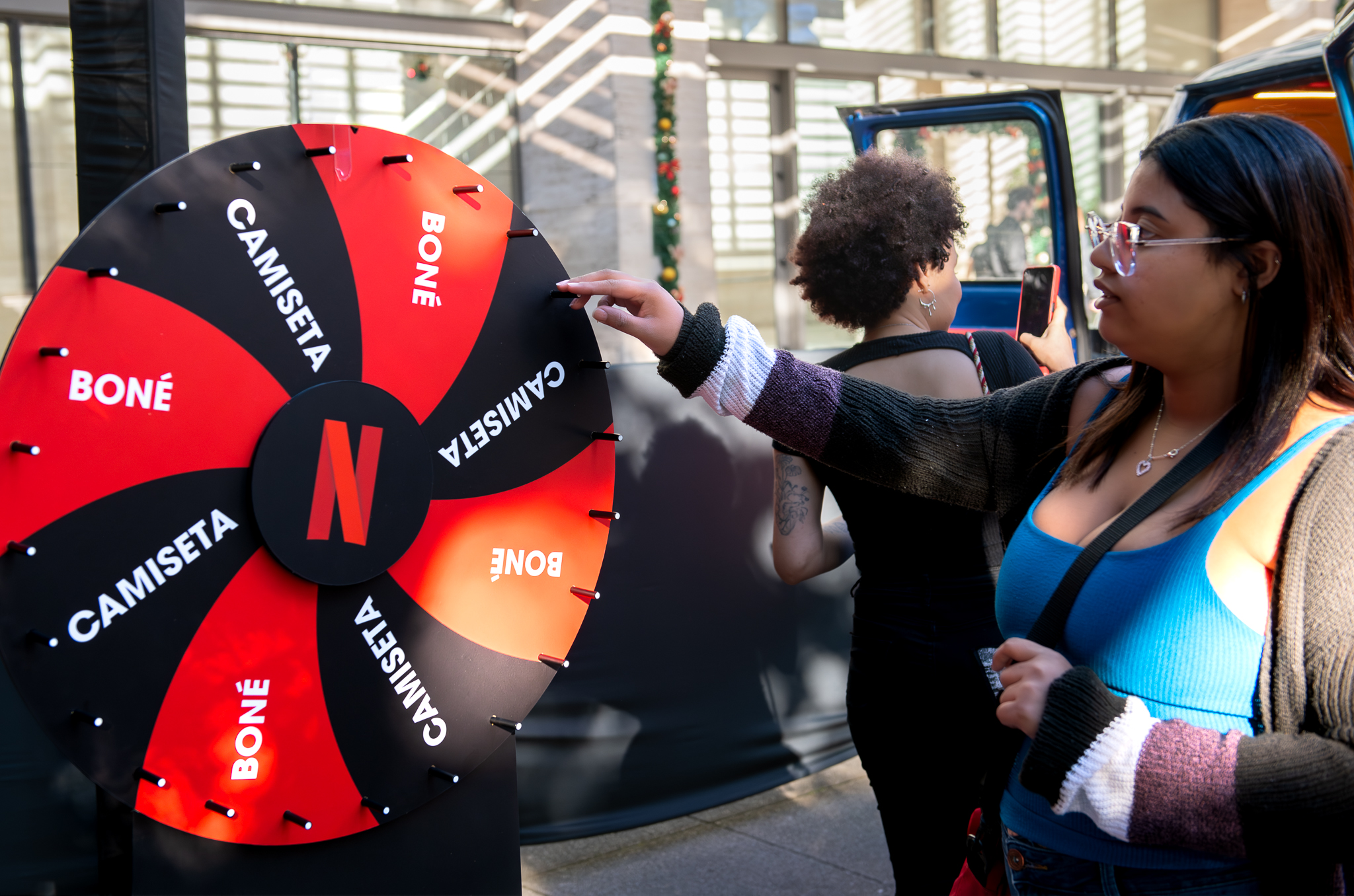 Consumidora girando roleta interativa da Netflix em ativação de live marketing em shopping center
